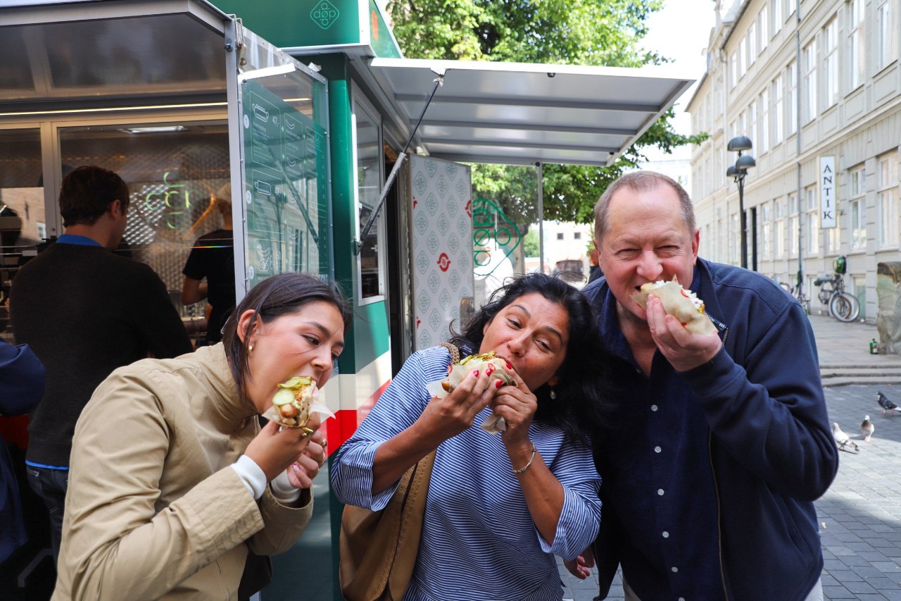 Guests eating hot dogs at Den Økologiske Pølsemand in Copenhagen