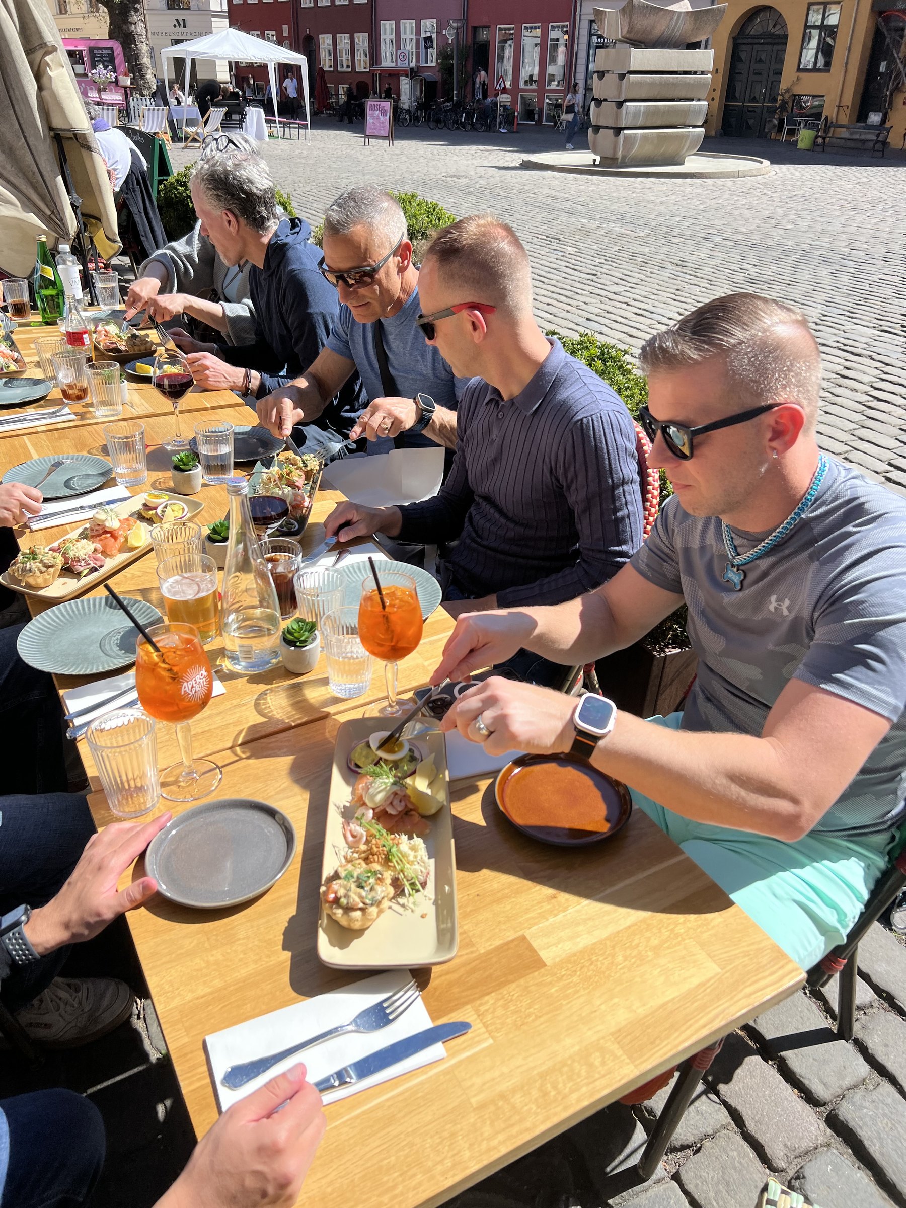 Guests eating at a sunny Copenhagen restaurant table